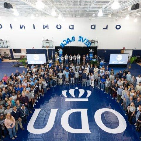 A group of people standing in a gym.